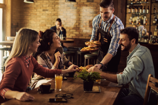Waiter Serving Customers At Table 600X400